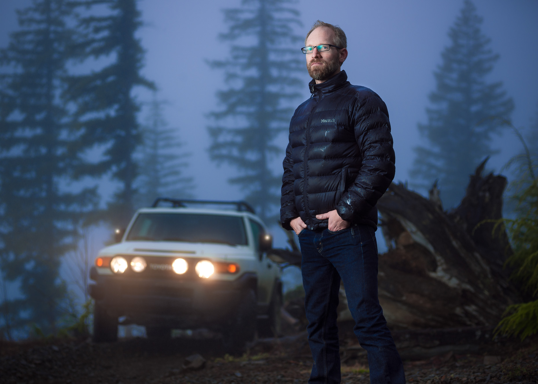 Dramatic twilight portrait in fog of guy and his SUV