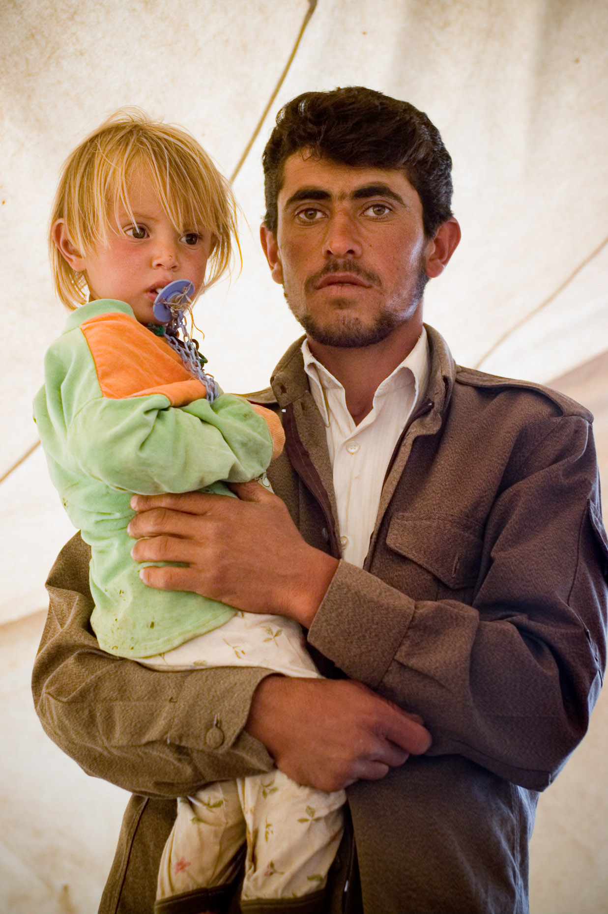 Portrait of Kurdish Peshmurga guard and his blond haired son. 
