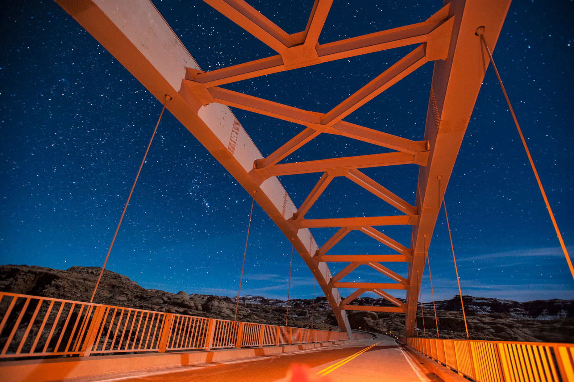Image of bridge structure at night with star lit sky over Colorado River, Utah. 