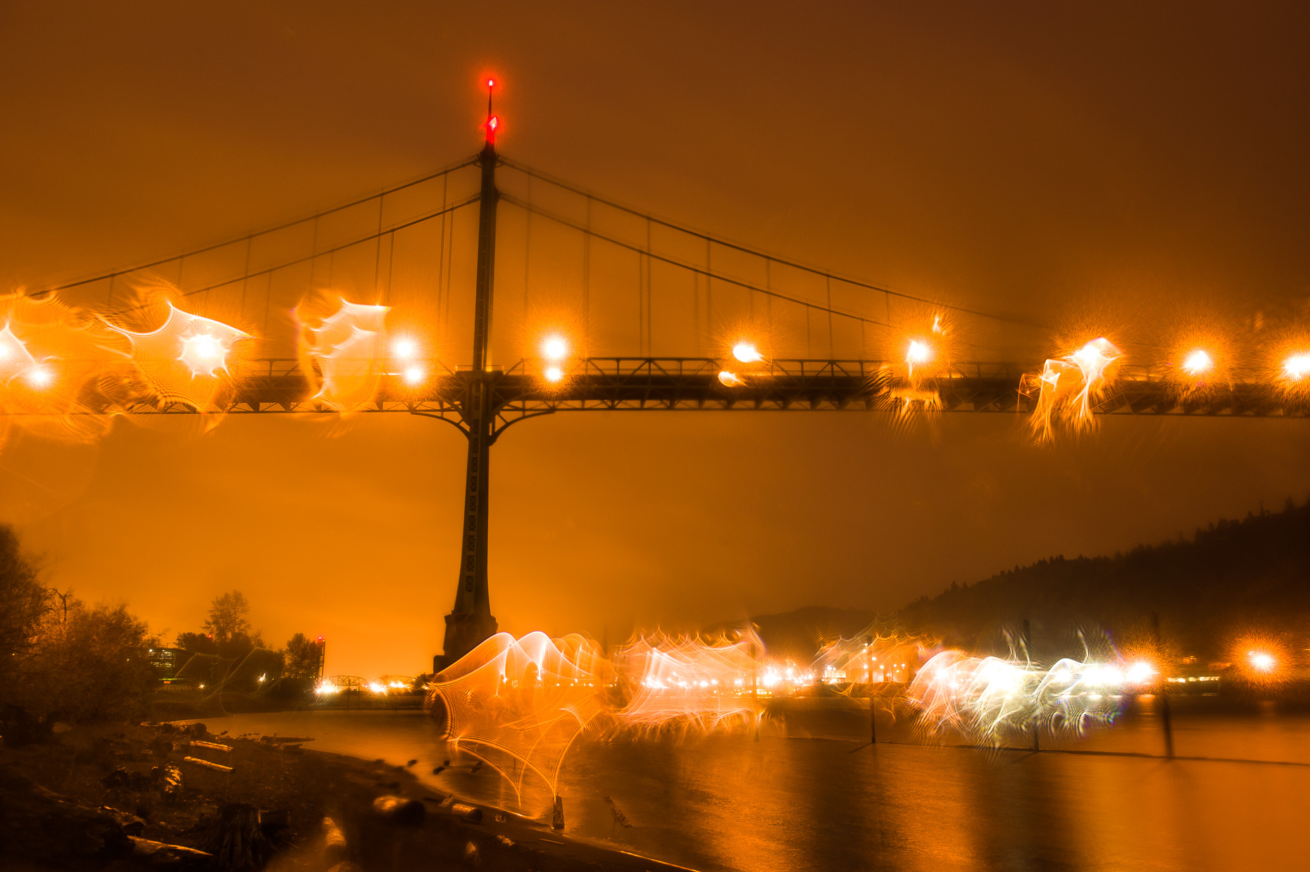 Night image of St. Johns Bridge with orange bridge lights, rain drops, Oregon. 