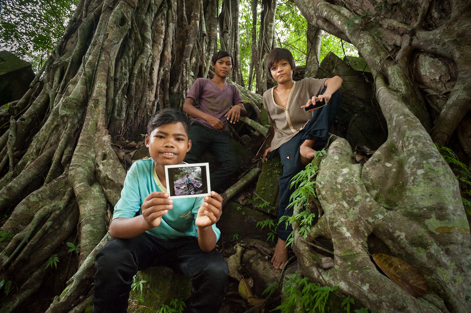 Cambodian kids with Polaroid pictures at Banteay Srey temple, Cambodia. 